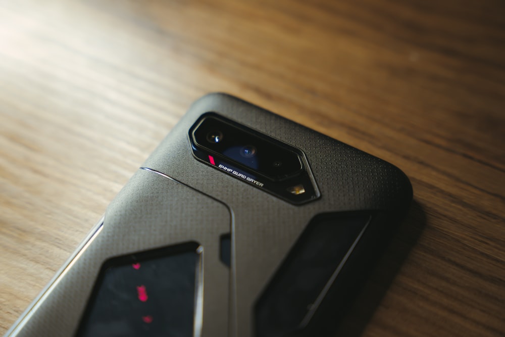 black and gray device on brown wooden table