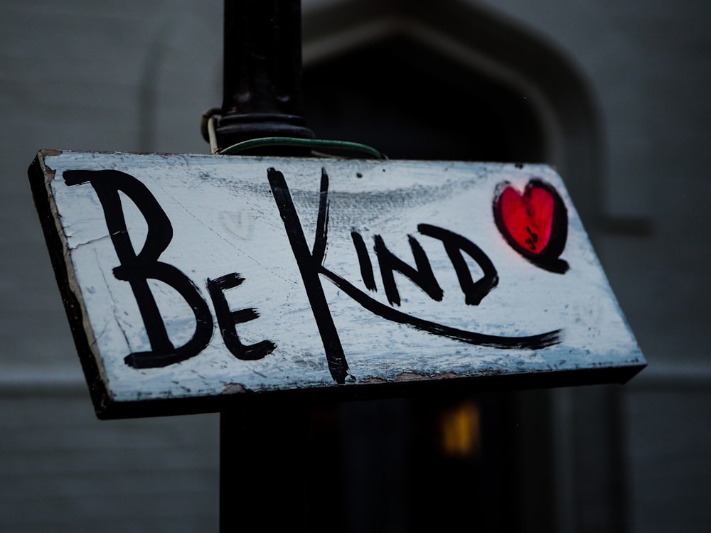 a sign that says be kind on it