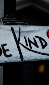 a sign that says be kind on it