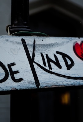 a sign that says be kind on it