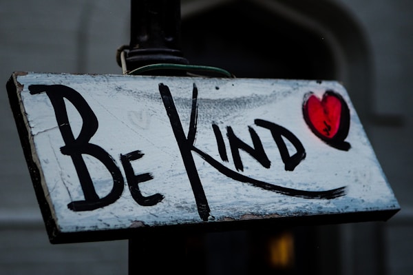 a sign that says be kind on it