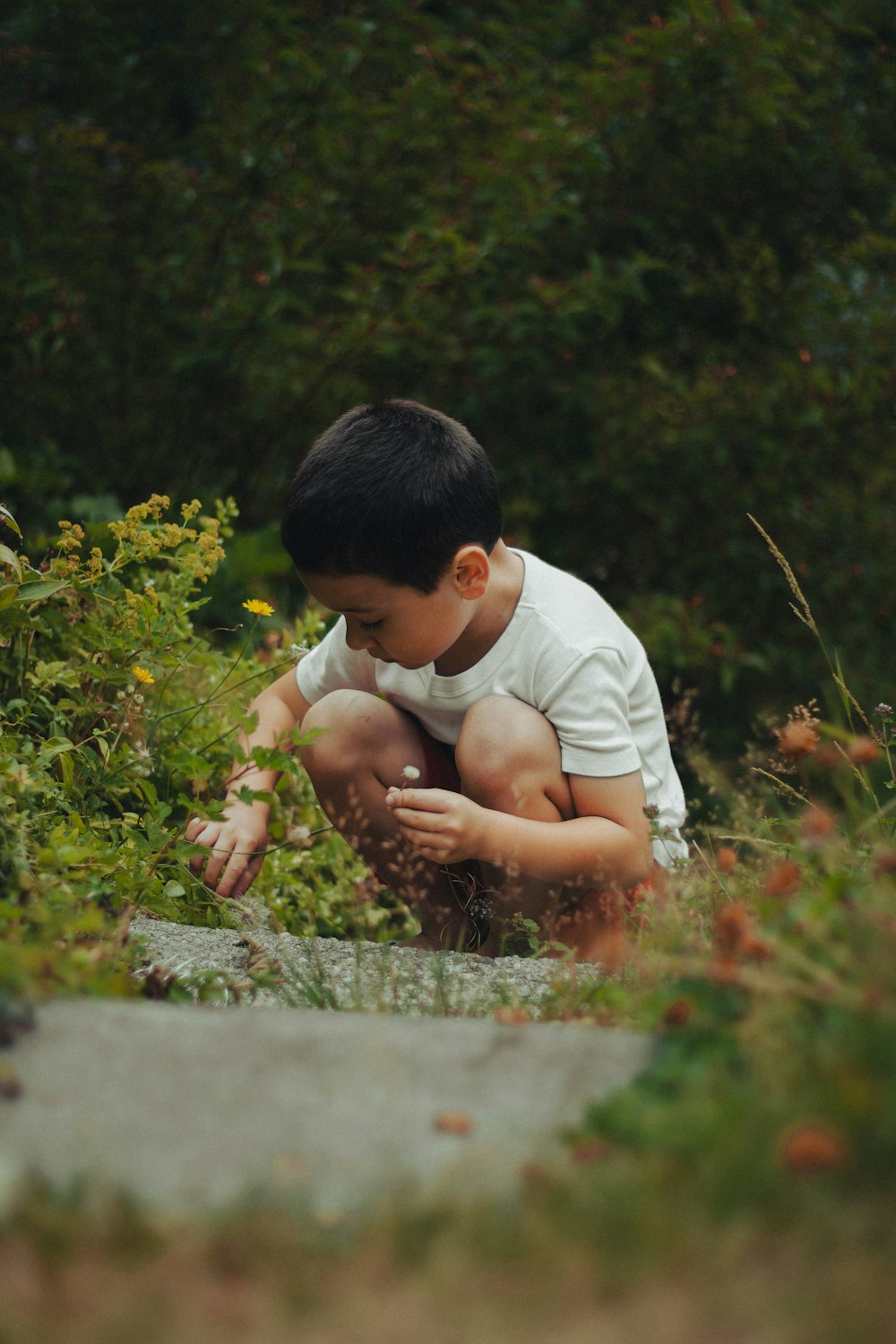 boy in white shirt sitting on ground