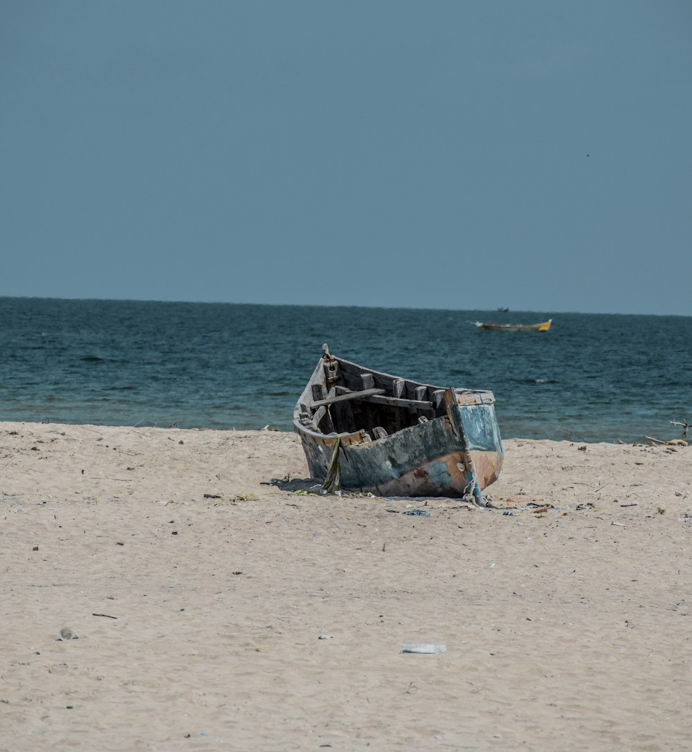 blue and white boat on beach during daytime