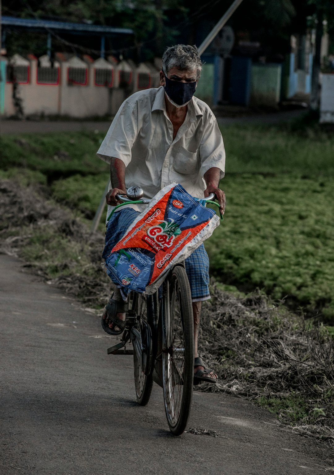 man in white button up shirt and blue denim jeans riding bicycle