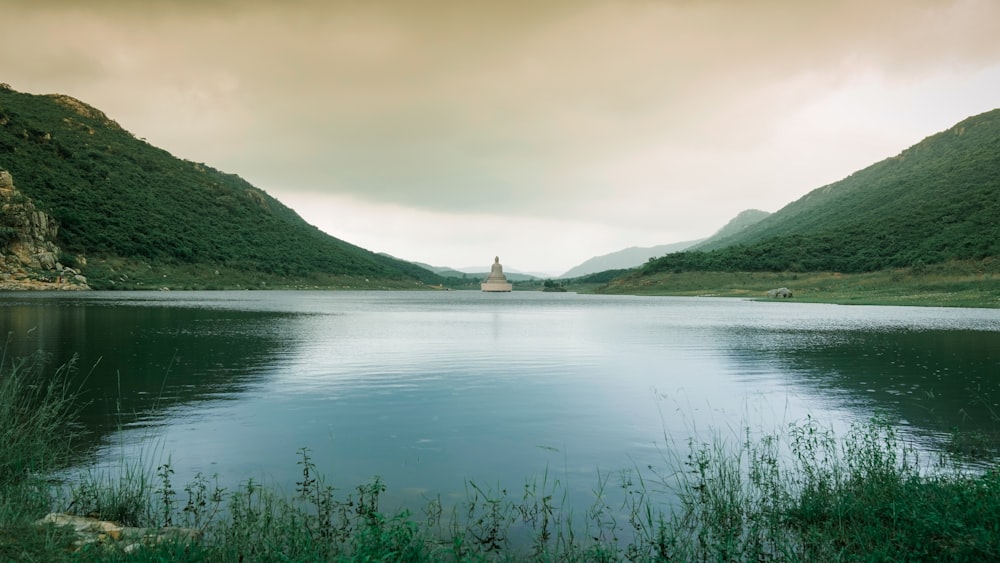 green grass on lake near mountain during daytime