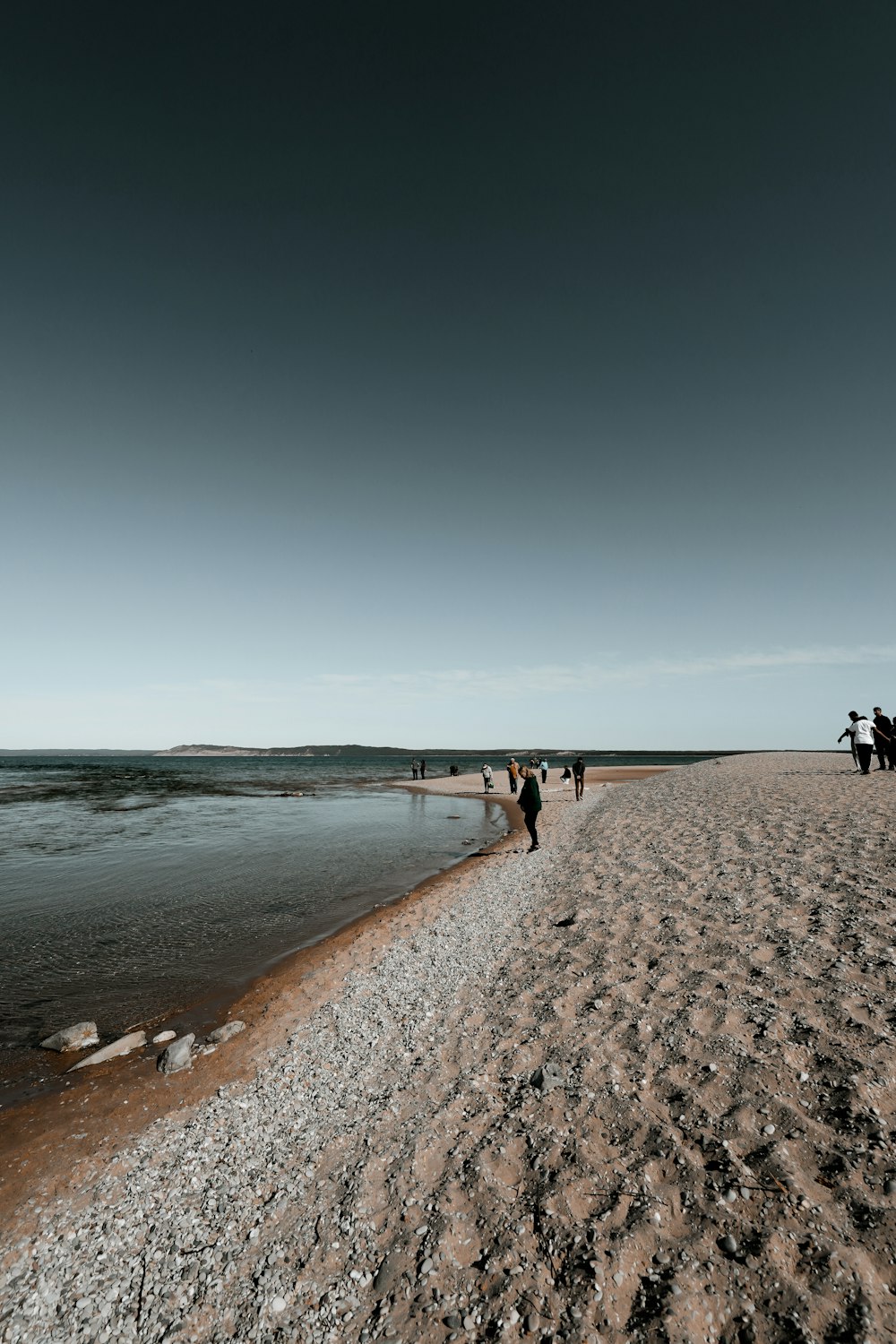 persone che camminano sulla spiaggia durante il giorno