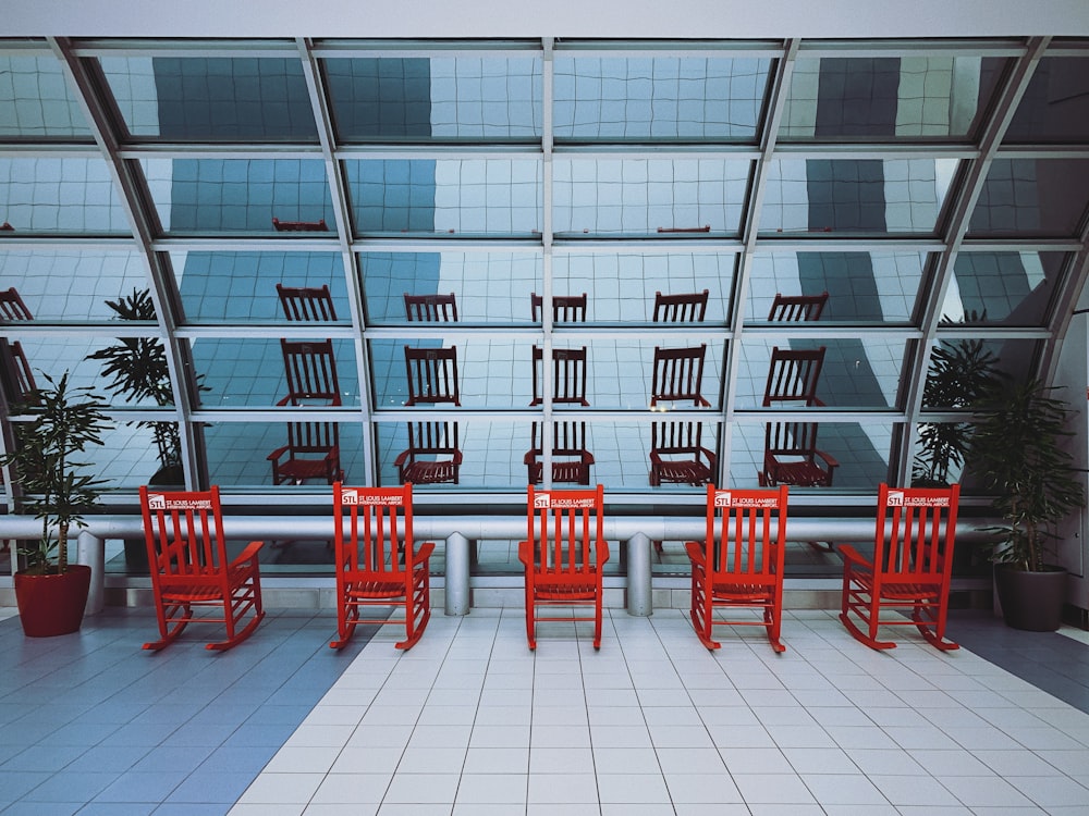 sedie di legno rosse vicino all'edificio della finestra di vetro