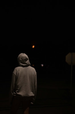 Evening light on a tactical hooded sweatshirt draped over a rock near a campfire.