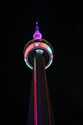 Colorful neon-themed radio tower transmitting digital music signals at night.
