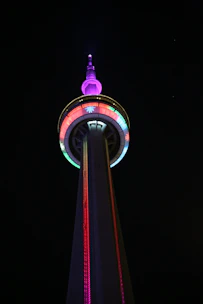 Colorful neon-themed radio tower transmitting digital music signals at night.
