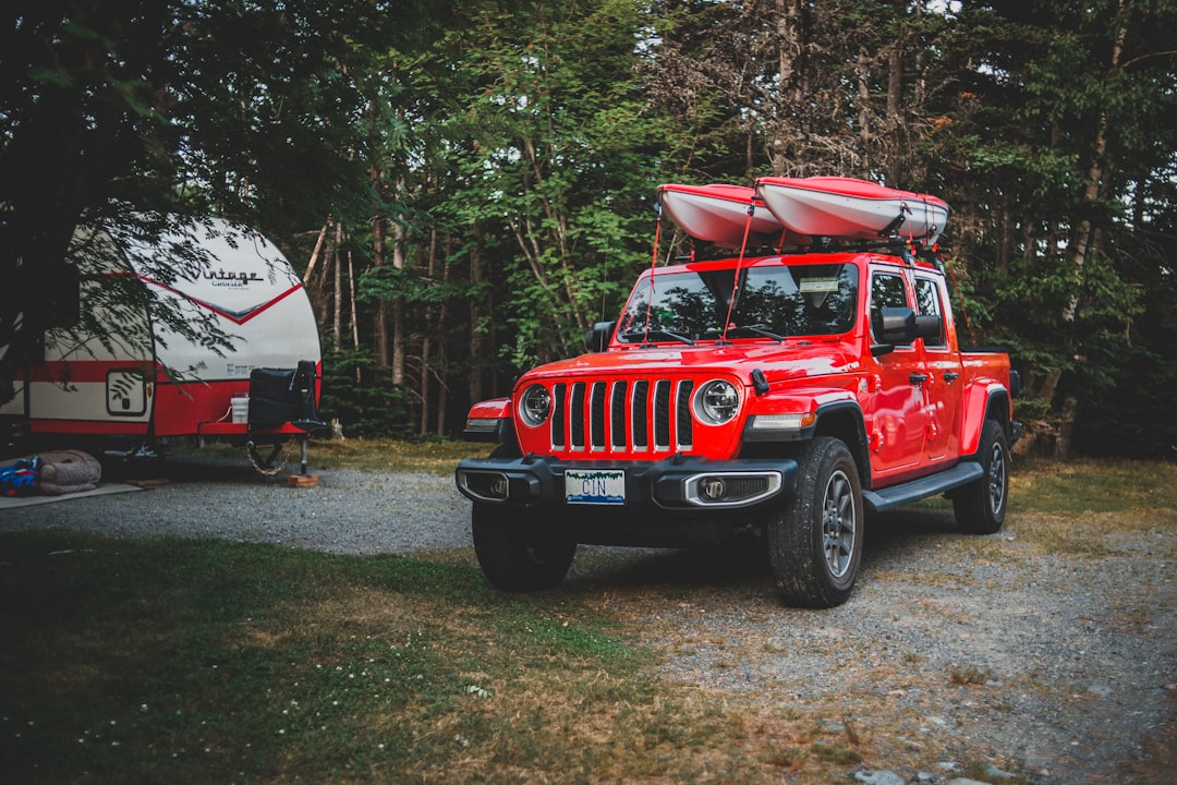 red jeep wrangler parked near trees during daytime