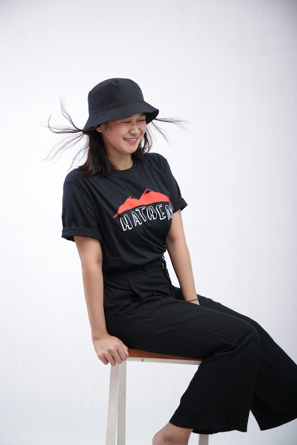woman in black and white crew neck t-shirt and black pants wearing black cap