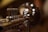 A close-up of a shiny brass trumpet with blurred circular lights in the background creating a bokeh effect. The foreground shows detailed parts of the trumpet, such as the valves and tubing, with reflections highlighting the polished metal surface.
