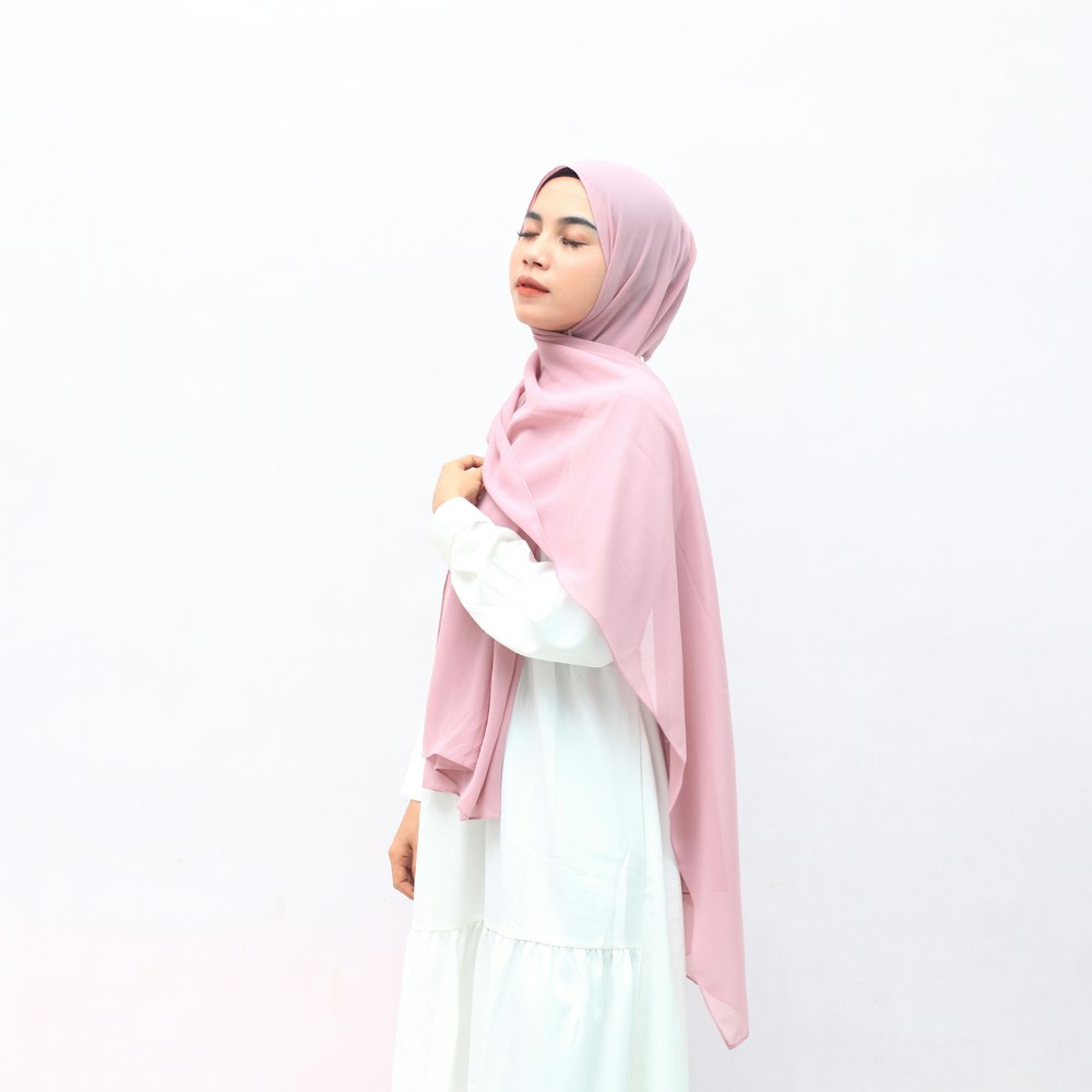 mulher no hijab cor-de-rosa e vestido branco de manga comprida