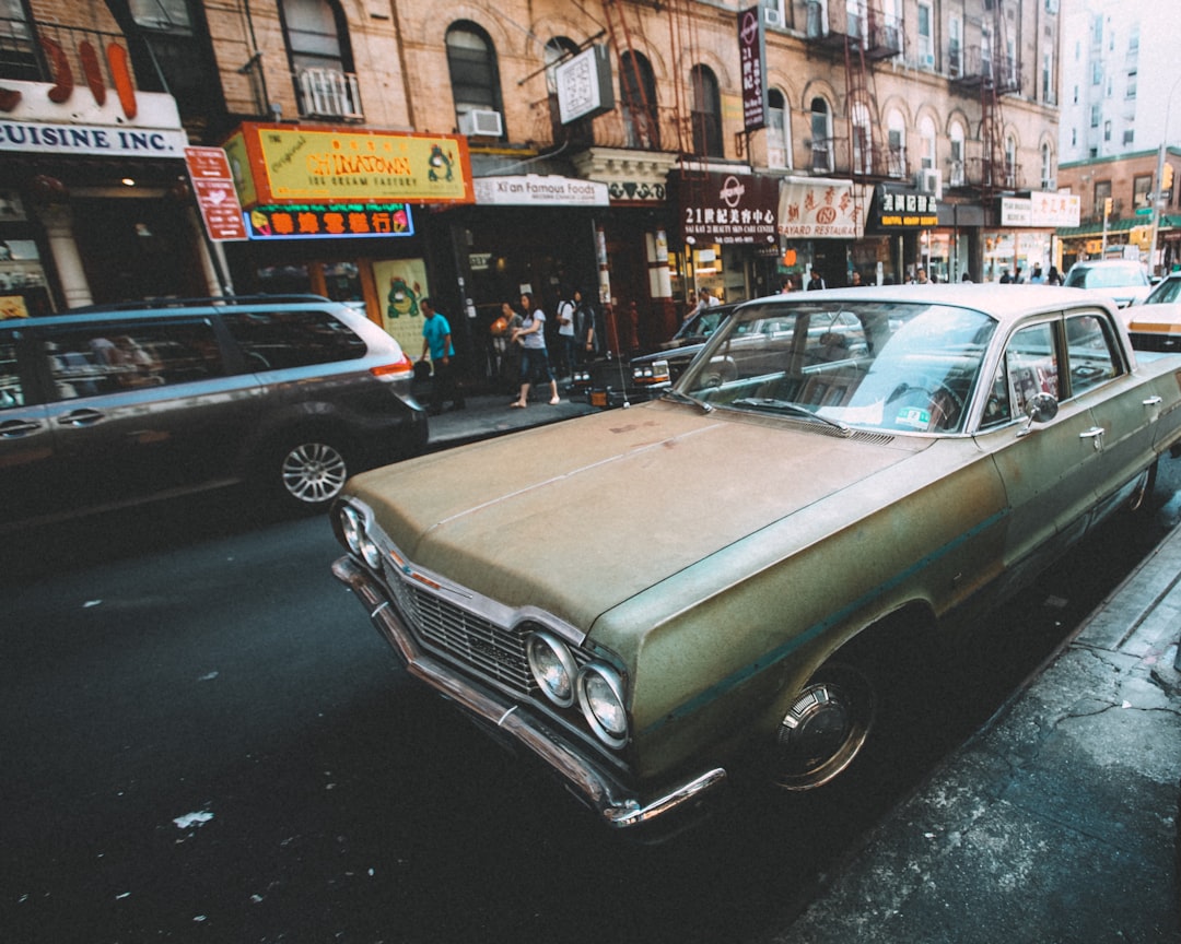 green classic car parked on sidewalk during daytime