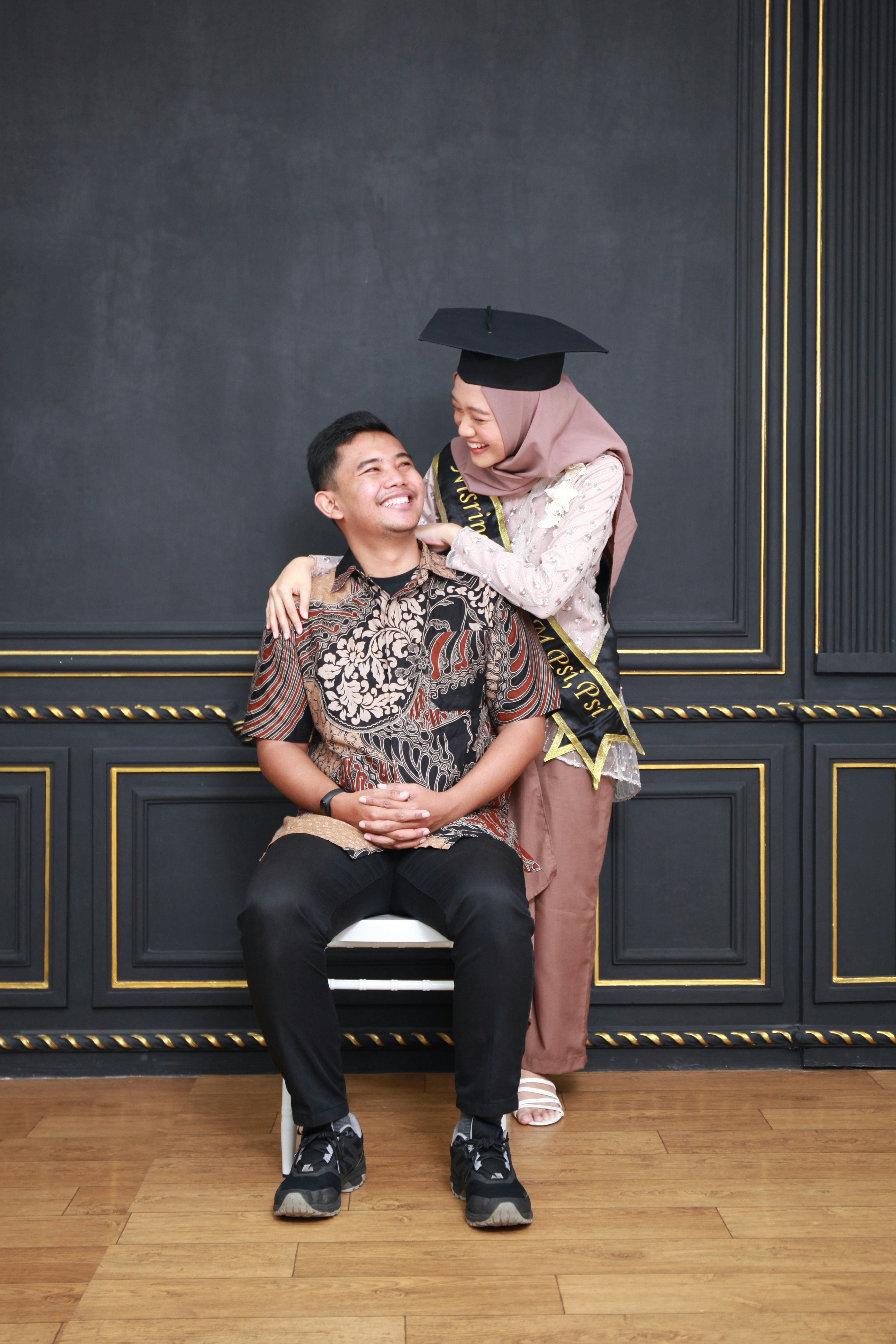 hombre y mujer sentados en un banco de madera negra