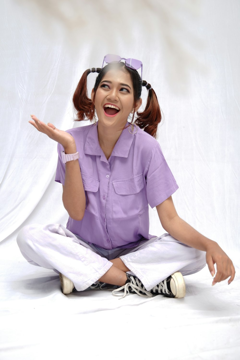 woman in purple polo shirt and white pants sitting on white floor