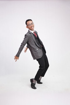 Harvey in his green cardigan and bowtie striking a playful pose against a clean, animated background.