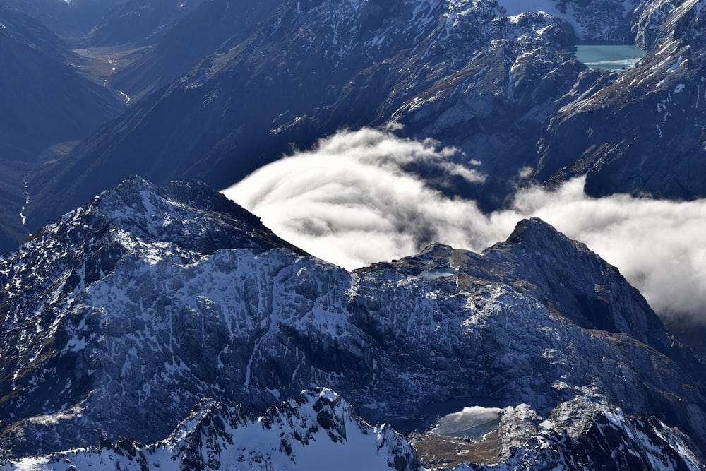 snow covered mountain under white clouds during daytime