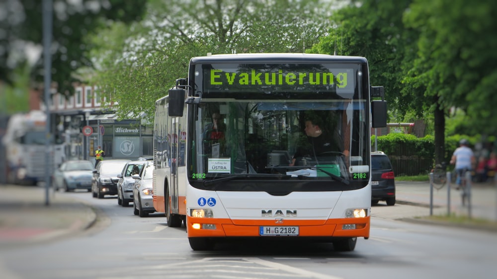 orange and black bus on road during daytime