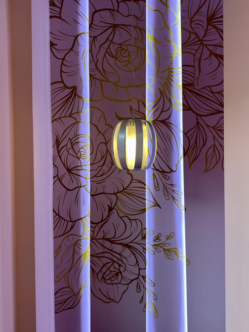 Living room wall showcasing intricate black wall stencil patterns highlighted by soft white paint background.