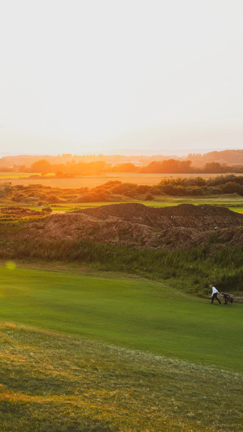 The fairway sweeping toward the mountains at golden hour