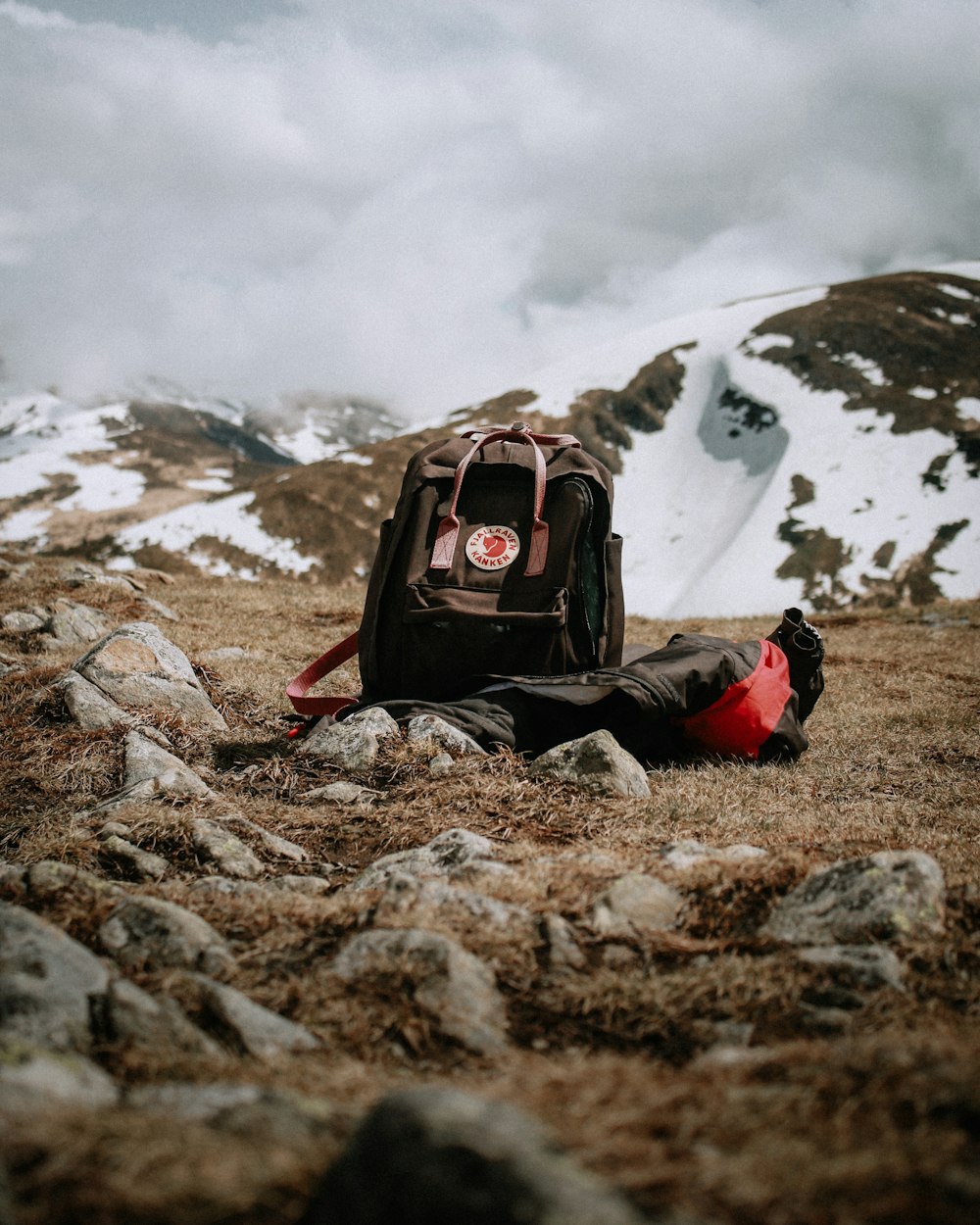 black and red backpack on brown rock