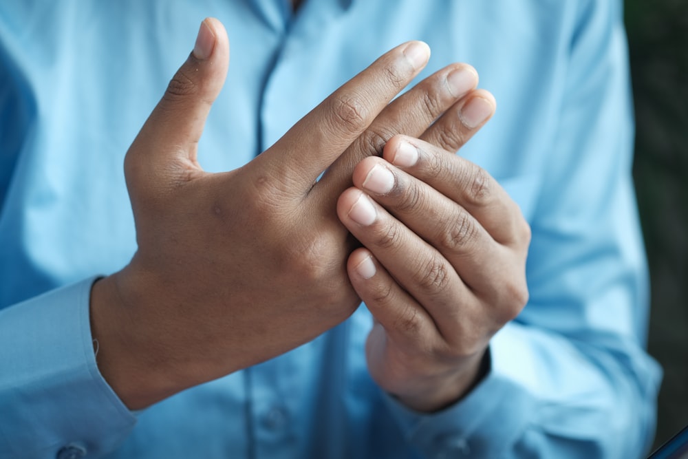 persona in camicia blu che mostra la mano sinistra