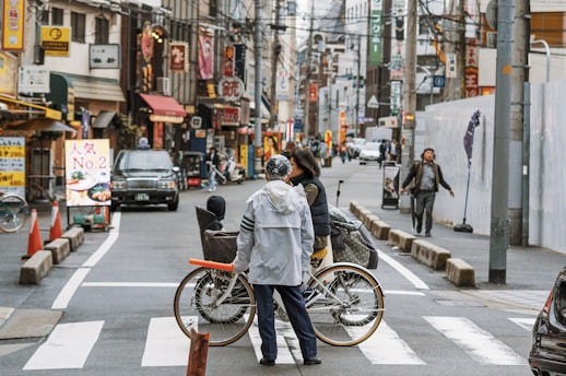 man in gray jacket riding bicycle on road during daytime