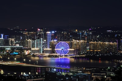 ferris wheel near city buildings during night time