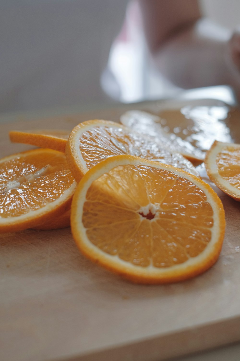 a cutting board topped with sliced oranges on top of a table