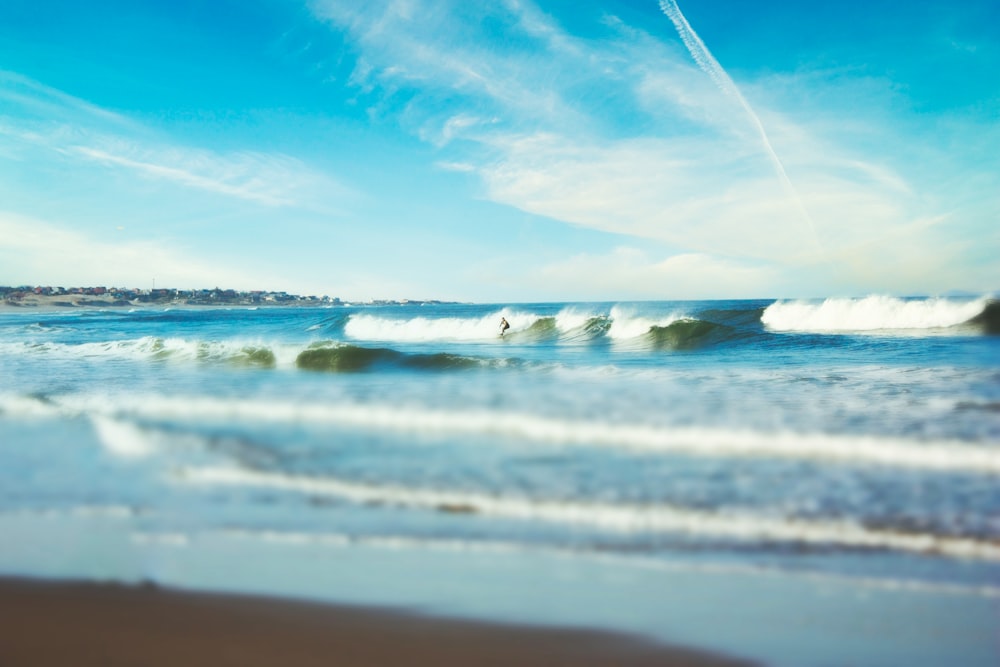 sea waves crashing on shore during daytime