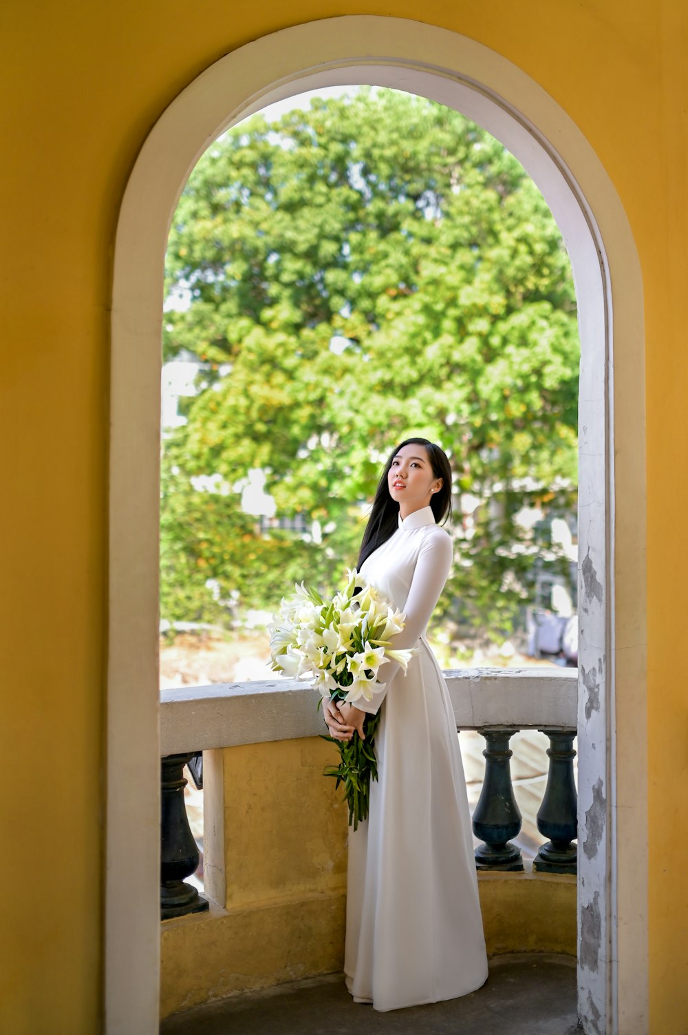 woman in white wedding gown holding bouquet of flowers