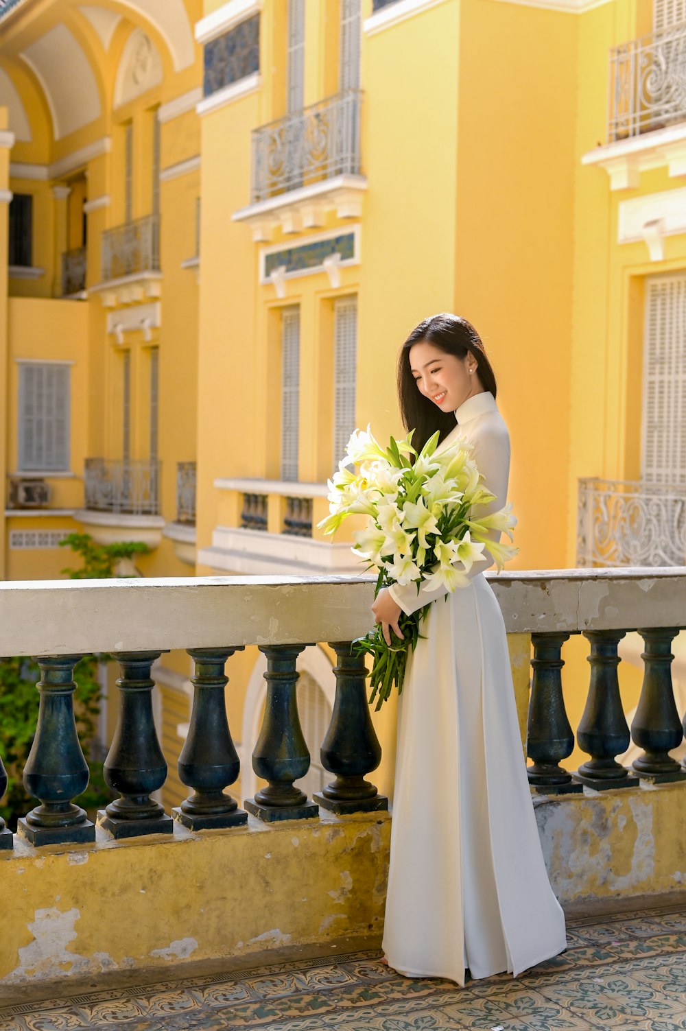 woman in white dress holding bouquet of flowers