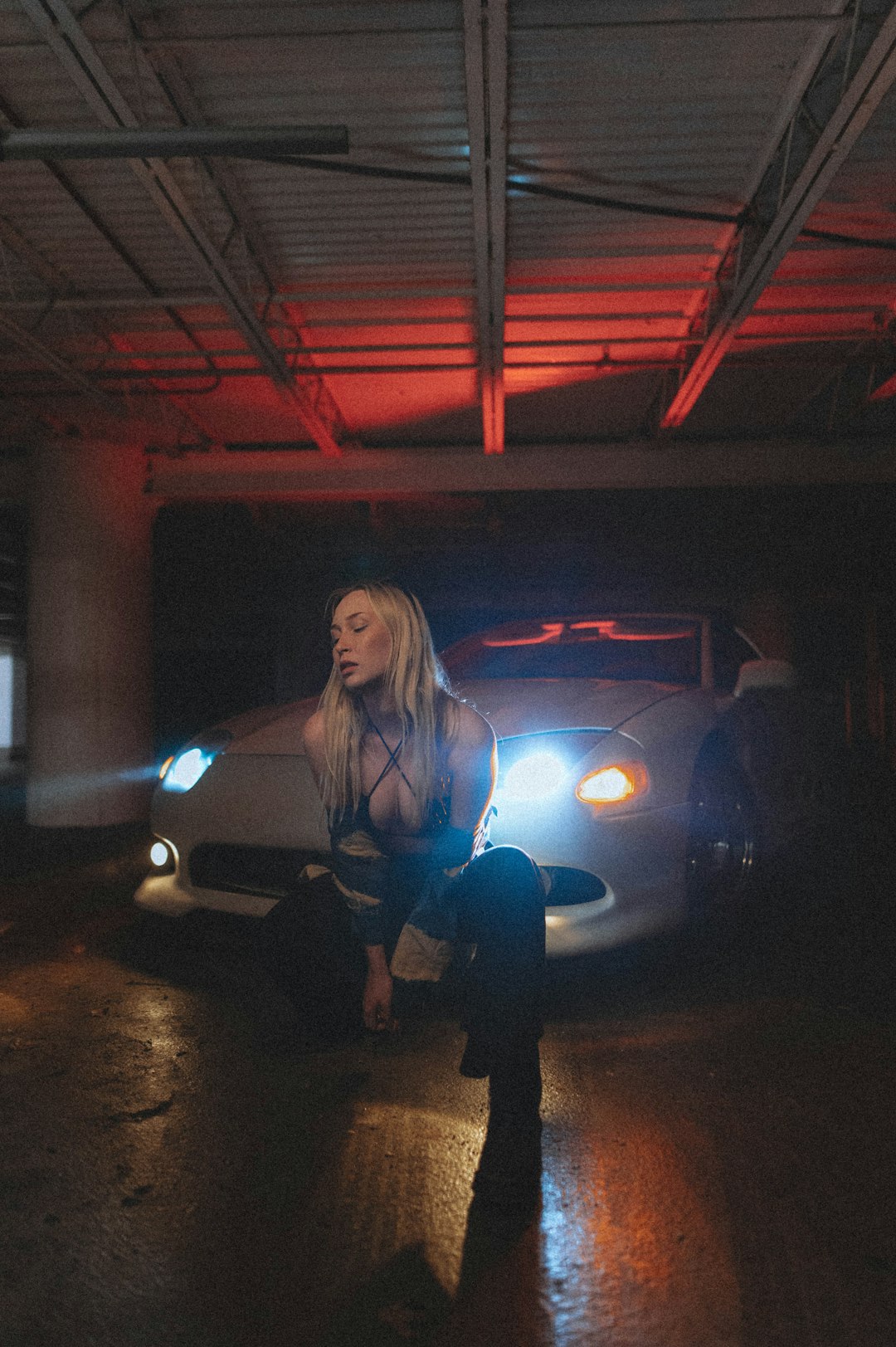 woman in blue long sleeve shirt standing beside white car