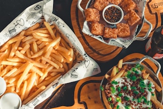Side dishes including fries and dipping sauces served on a rustic wooden table.