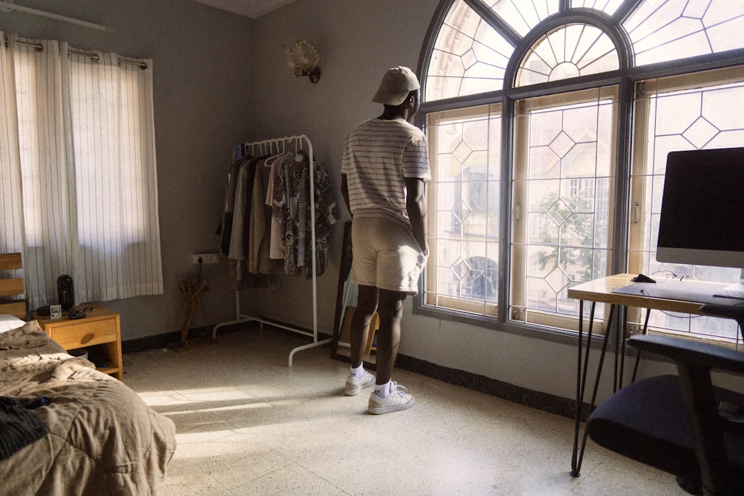 woman in white and black stripe long sleeve shirt standing near window