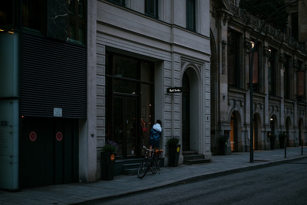 昼間、歩道で自転車に乗る青いジャケットの男
