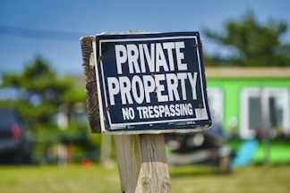 a private property sign posted on a wooden post
