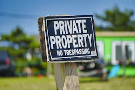 a private property sign posted on a wooden post