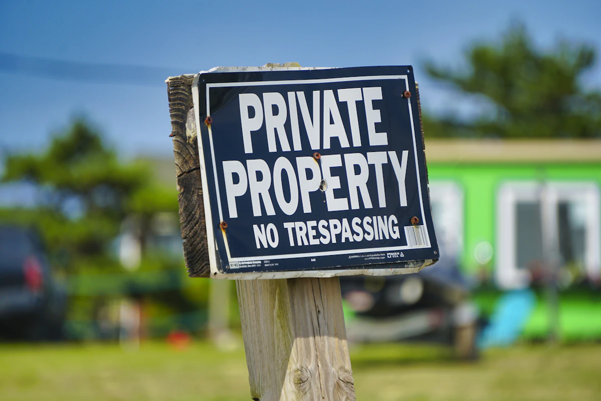 A private property sign posted on a wooden post