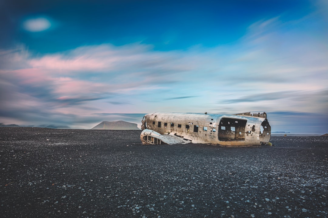 white and black bus on gray sand under blue sky during daytime