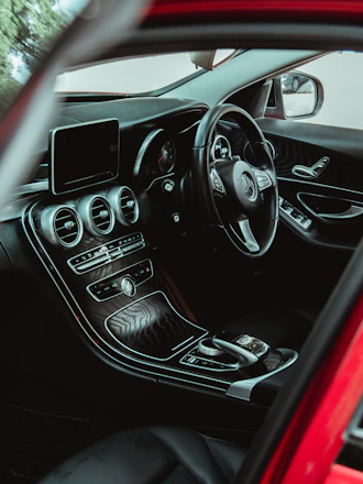 Close-up of a matte black luxury car dashboard illuminated by razor-thin gold accent lines.
