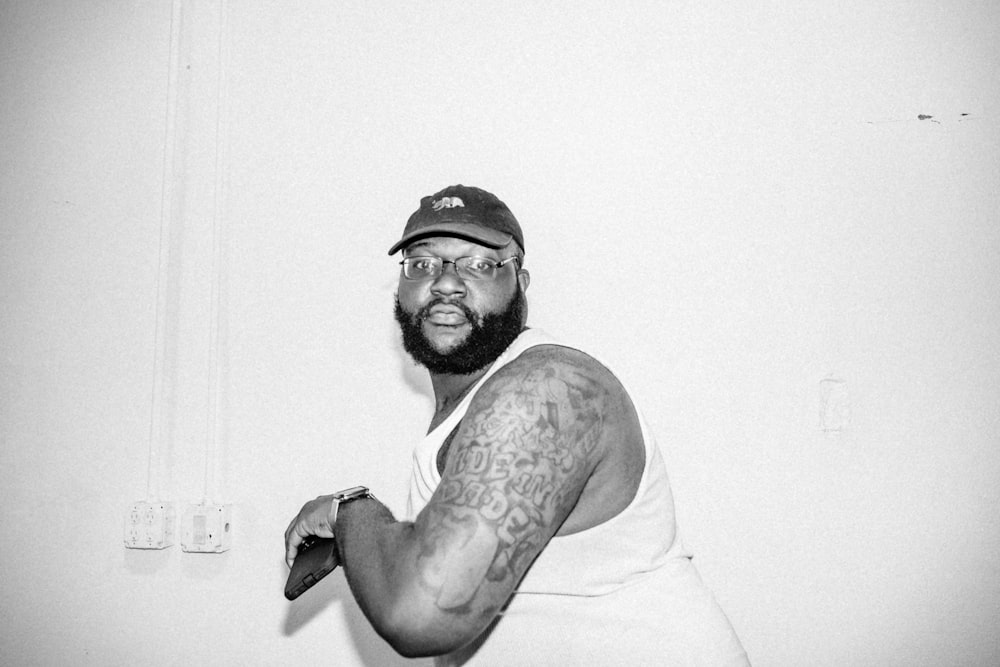 man in tank top wearing black cap