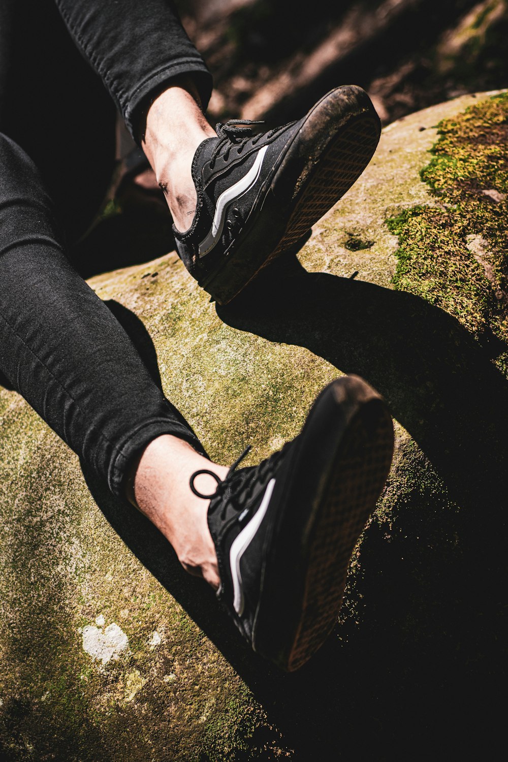 person in black pants and black and white nike sneakers