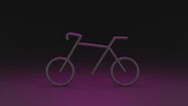 A stylized and minimalistic outline of a bicycle with neon pink lighting against a dark background. The bicycle shape is created using simple lines and circles, giving it a futuristic appearance.