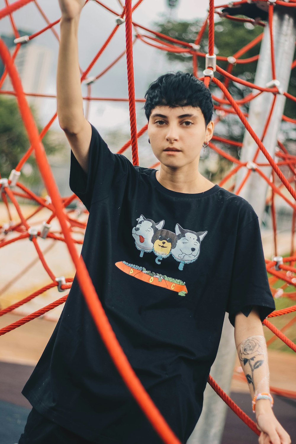 boy in black crew neck t-shirt standing near red metal frame