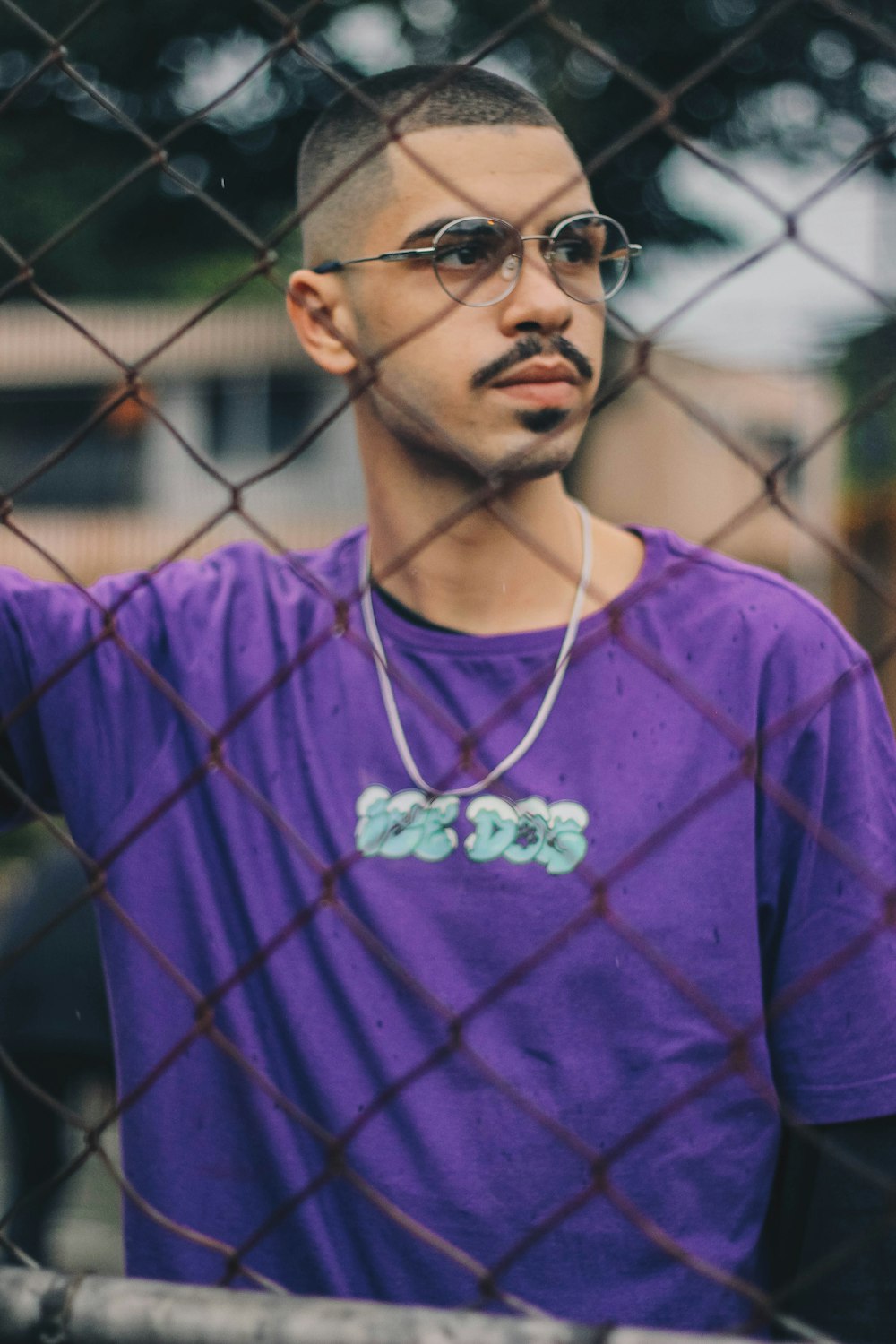 man in purple crew neck long sleeve shirt wearing black sunglasses