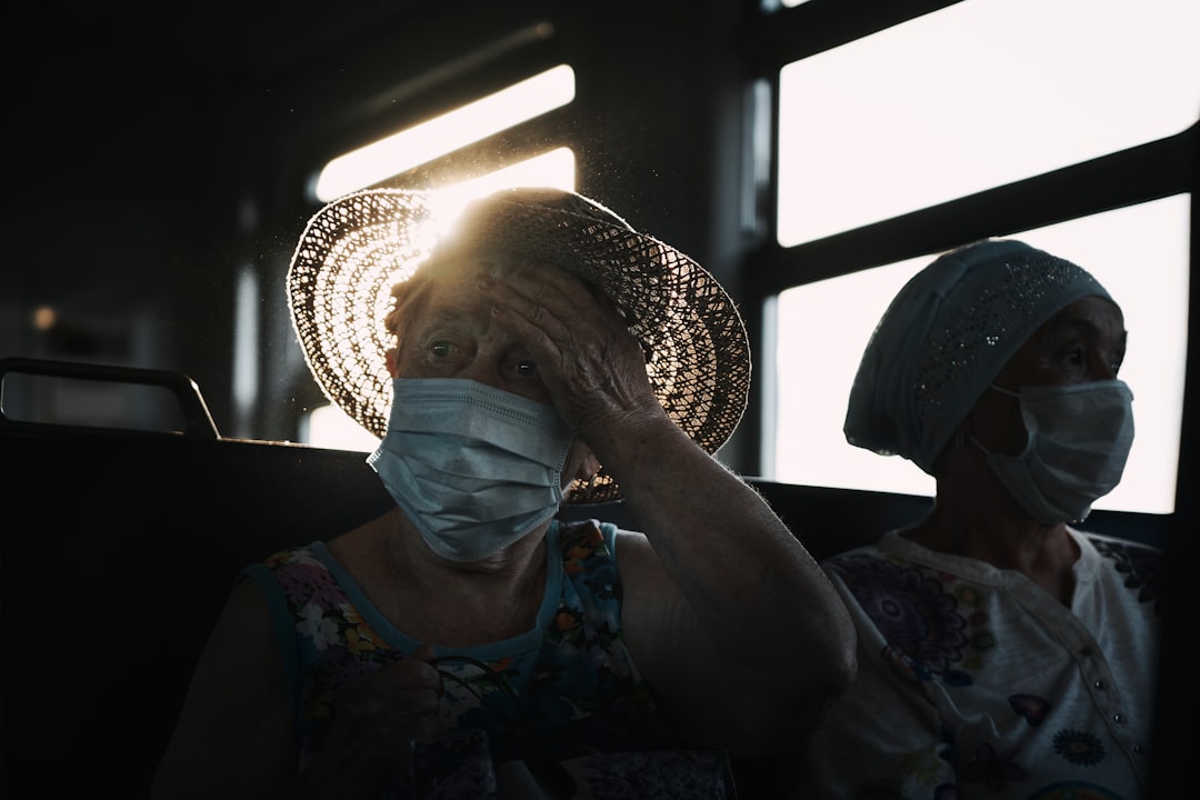 woman in blue and white floral shirt wearing brown straw hat