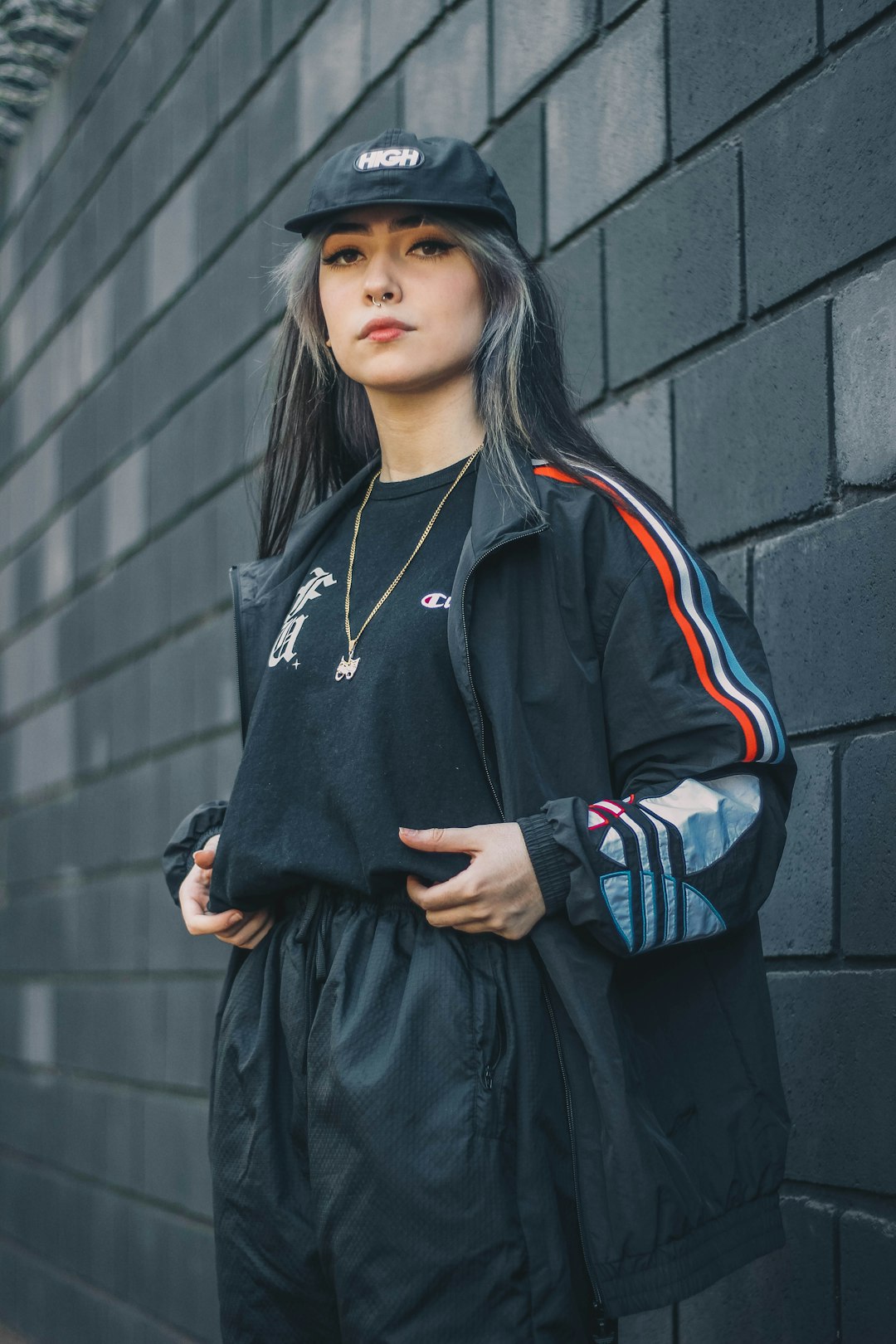 woman in black and white adidas zip up jacket and black skirt